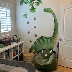 a child's bedroom with a dinosaur mural on the wall