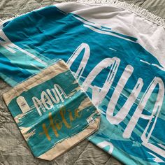 a blue and white towel sitting on top of a bed next to a bag with the word hello hope written on it