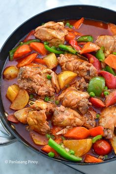 a pan filled with meat and vegetables on top of a table