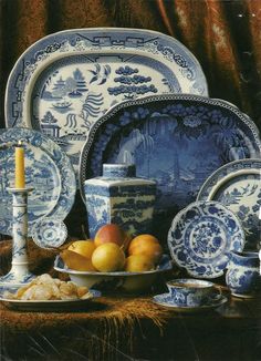 an assortment of blue and white plates, bowls, and vases on a table