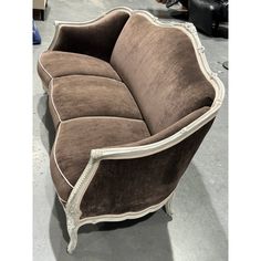 a brown and white couch sitting on top of a floor