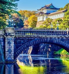 a bridge over a body of water with a building in the background