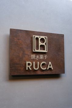 a wooden sign that says ruca on the side of a building with chinese writing