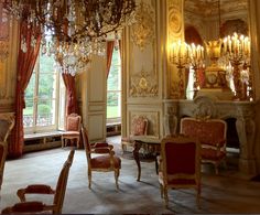 an ornate room with chandeliers and chairs