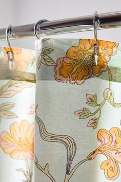 a curtain with flowers on it hanging from a rod