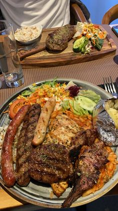 a plate full of meat and vegetables on a table