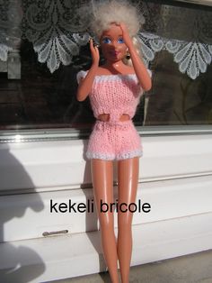 a doll is posed in front of a window