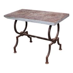 a table that is sitting on top of a white surface with metal legs and a stone top