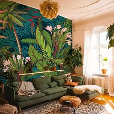 a living room filled with lots of furniture and walls covered in tropical wallpapers