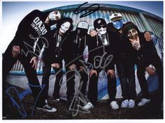 an autographed photo of five people with their faces painted in black and white