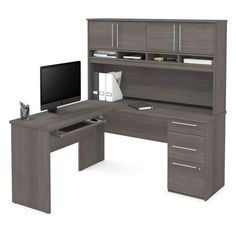 a computer desk with a monitor and drawers