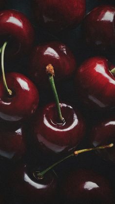 an oil painting of red cherries with green stems