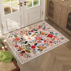 a white door mat with flowers and leaves on it in front of a wooden floor