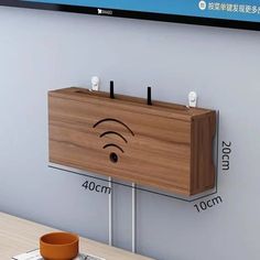 a wooden cabinet with two wifi signals on the wall next to a coffee cup