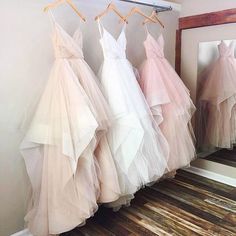 three dresses hanging on a rack in front of a mirror