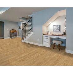 an empty room with hard wood floors and blue walls is pictured in this image, there are two stools at the end of the desk