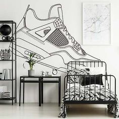 a black and white drawing of a sneaker shoe on a wall next to a bed