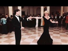 two people dressed in black dancing on a dance floor