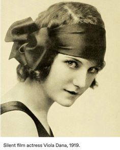 an old black and white photo of a woman wearing a hat with a bow on it