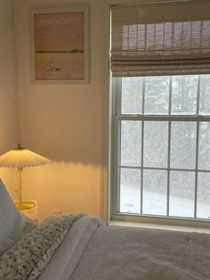 a bedroom with a bed, lamp and window