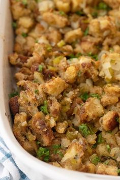 a casserole dish with stuffing and vegetables in it on a blue and white towel