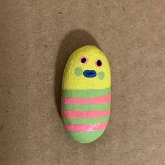 a painted rock that looks like a caterpillar with two eyes and one nose