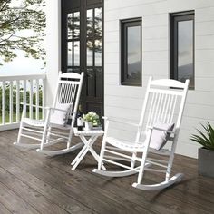 two white rocking chairs sitting on top of a wooden deck