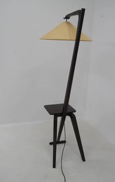 a lamp that is sitting on top of a table next to a chair with a light on it