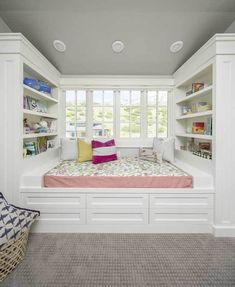 a bedroom with built in bookshelves and a window seat