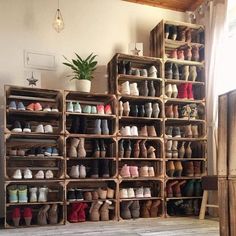 a room filled with lots of wooden crates and shoes on top of each other in front of a window