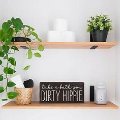 two wooden shelves with plants and toiletries on them, one has a sign that says take a little you dirty hippie