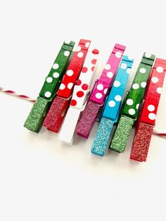 four different colored toothbrushes with polka dots on them, tied to a string