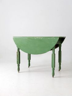 a small green table with two legs on each side and one leg raised up to the ground