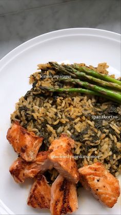 chicken and rice with asparagus on a white plate, ready to be eaten