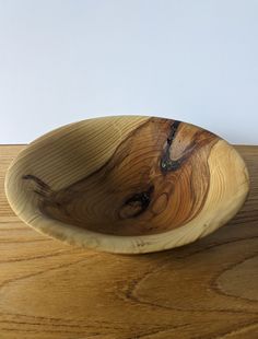 a wooden bowl sitting on top of a wooden table