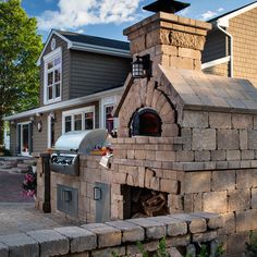 an outdoor pizza oven built into the side of a house