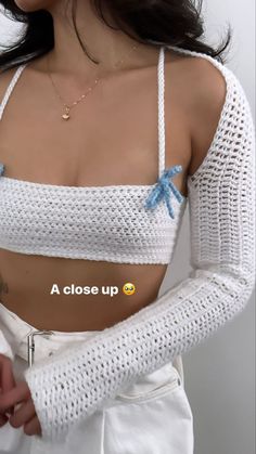 a close up of a woman wearing a white top and blue bow tie around her waist