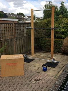 a box sitting on top of a patio next to a pull up bar and kettle