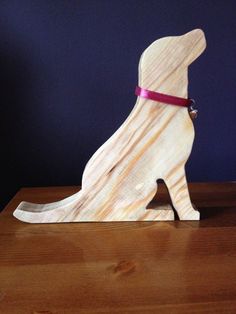 a wooden sculpture of a dog with a red collar