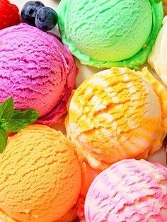 several different colored ice creams are arranged in a circle with mint leaves on top