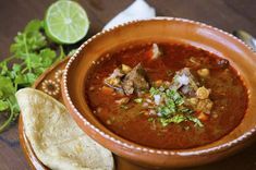 a close up of a bowl of soup on a table with tortilla chips