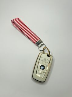 a keychain with a red and white striped lanyard attached to the front