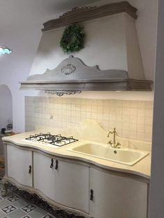 a kitchen with two sinks and a range hood above the stove in front of it