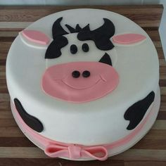 a cake decorated with a cow's face and pink bow