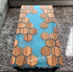 a glass table with wooden hexagons on it in front of a couch