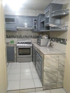 a kitchen with gray cabinets and tile flooring