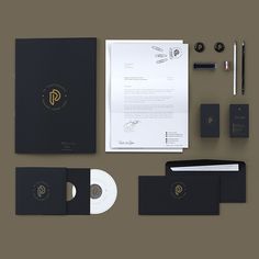 various stationery items are displayed on a table with the letter p in gold and black