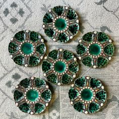 four green and white plates sitting on top of a carpeted floor next to each other