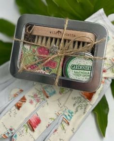 "Here's a darling gift for Gardeners who love to toil in the earth's soil.  Gardener's and hard workers with dry hands, and in need of cuticle repair, this gift set is for you!  Gardening Gift Set Includes: + 1 ounce Gardener's Healing Balm and Cuticle Cream + 2 ounce bar organic eucalyptus and tea tree soap + Natural two sided nail brush + Packaged in a 5\" x 4\" x 1.5\" window tin ideal for storing seeds, tags and twine. The gardener's gift tin is wrapped with twine and a keepsake silver garde Unique Coworker Gifts, Storing Seeds, Cuticle Repair, Gardening Gift Set, Gifts For Gardeners, Tea Tree Soap, Garden Gloves, Cuticle Cream, Gardening Gifts