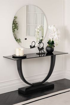 a table with a mirror and vase on it